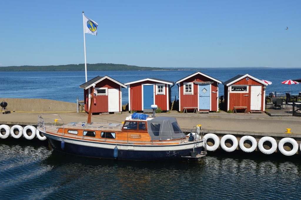 little huts, a boat, a flag by the sea while remote work in winter