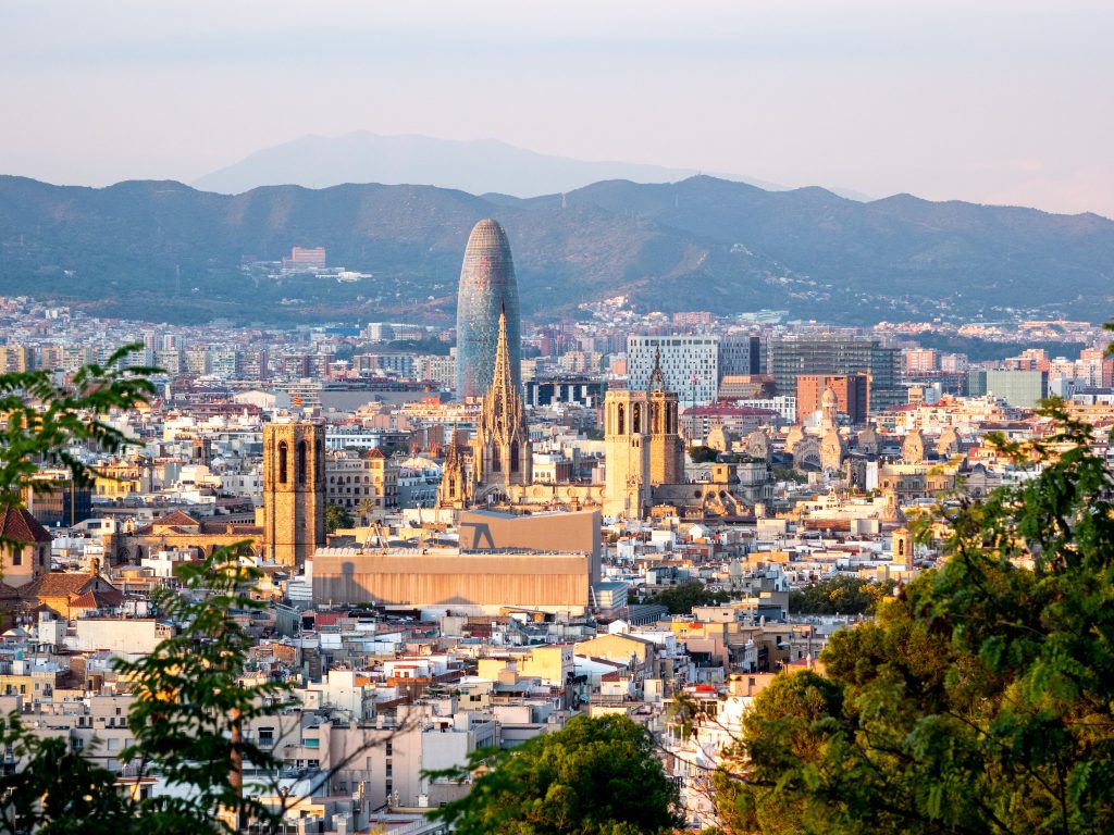 a city view of Barcelona, Spain with the sangria la familia in the middle during the day.