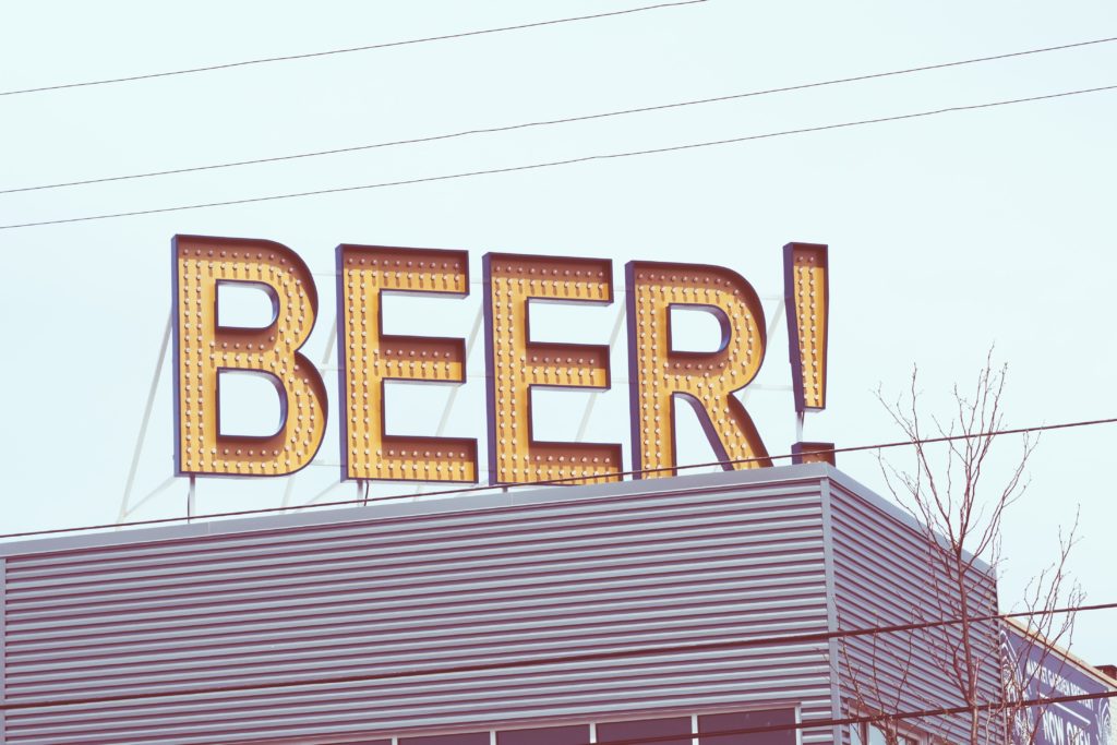 A sign on the top of a roof saying BEER! 