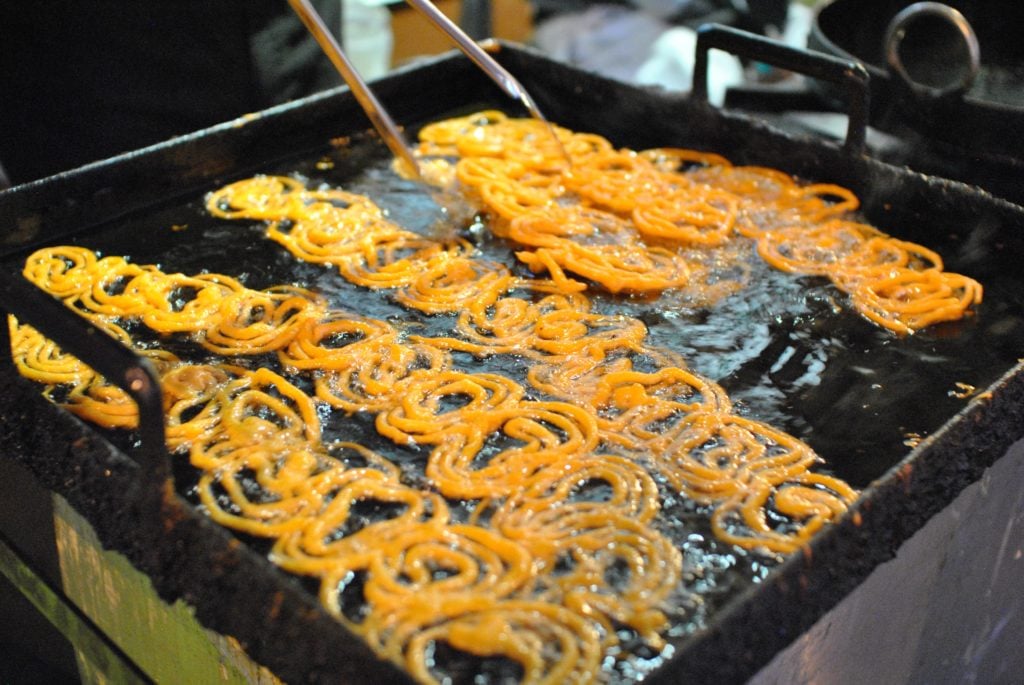 Jalebi, eine Indische Köstlichkeit wird in heißem Öl frittiert. 