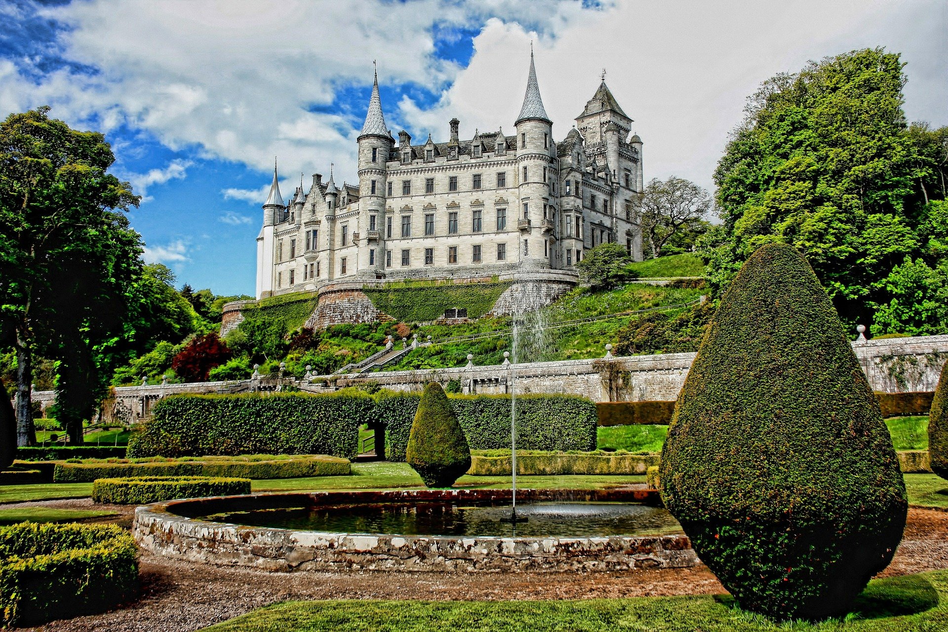 The white Dunrobin castle in Scotland with beautiful gardens in front