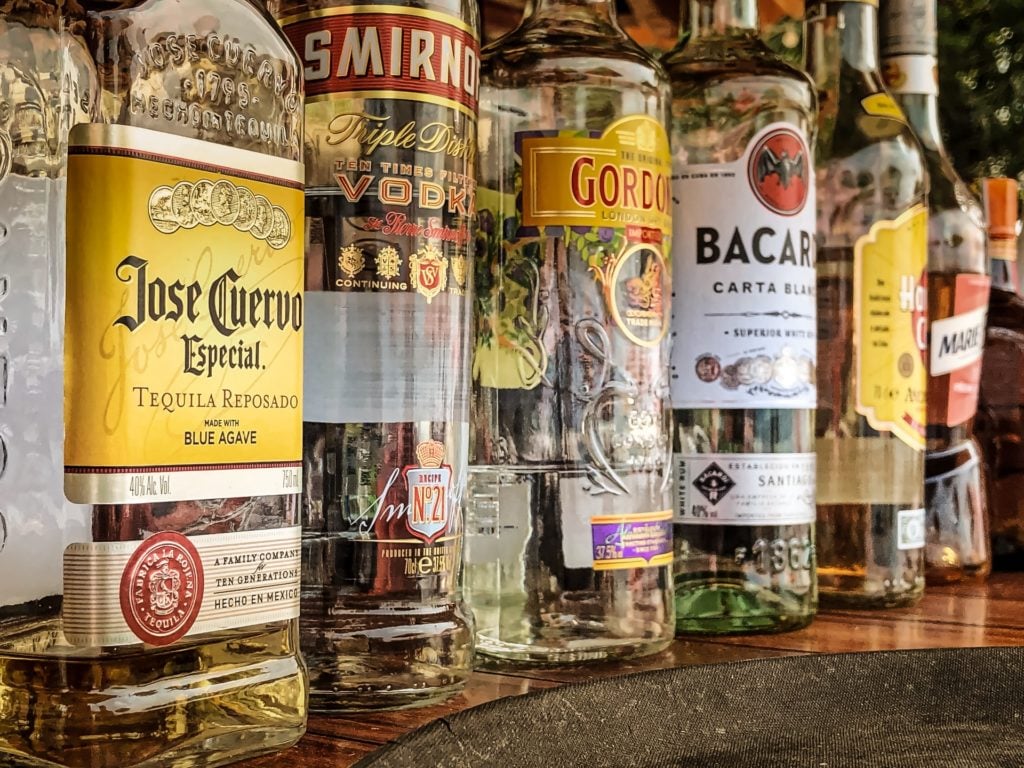 multiple bottles of alcohol lined up against eachother