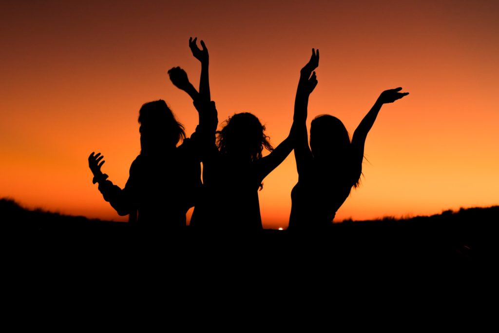 silhouette of three women, while Traveling in groups in the beautiful sunset