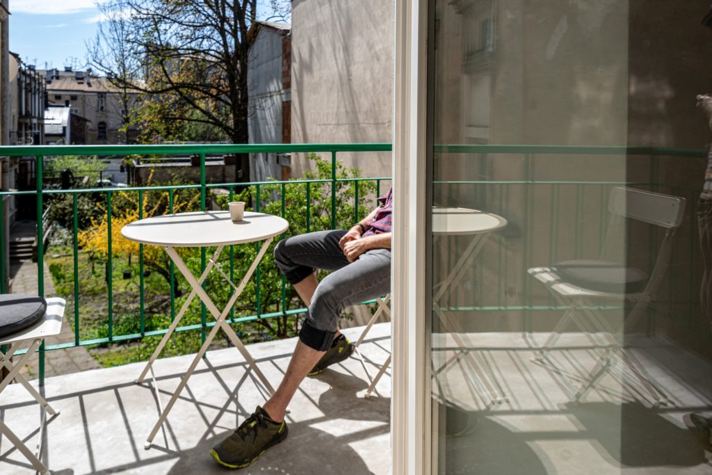 man sat on the balcony with a coffee taking a break