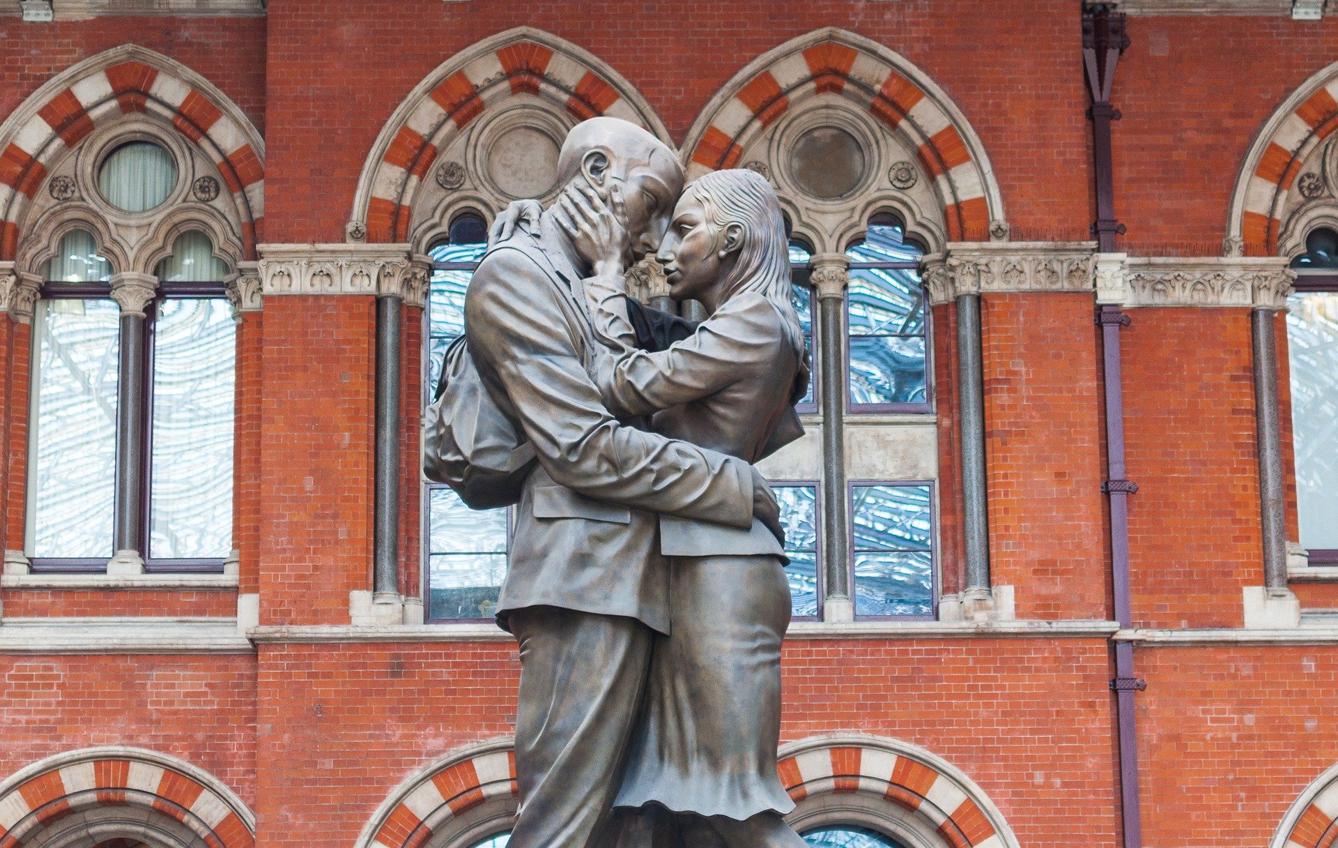 Eine Statue von einem Man und einer Frau, welche sich liebevoll voneinander verabschieden, ander St. Pancras Station in London. 