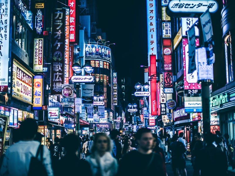 Eine sehr belebte Straße in Tokio, mit unzähligen bunten und verschiedenen Leichtreklamen und Bannern