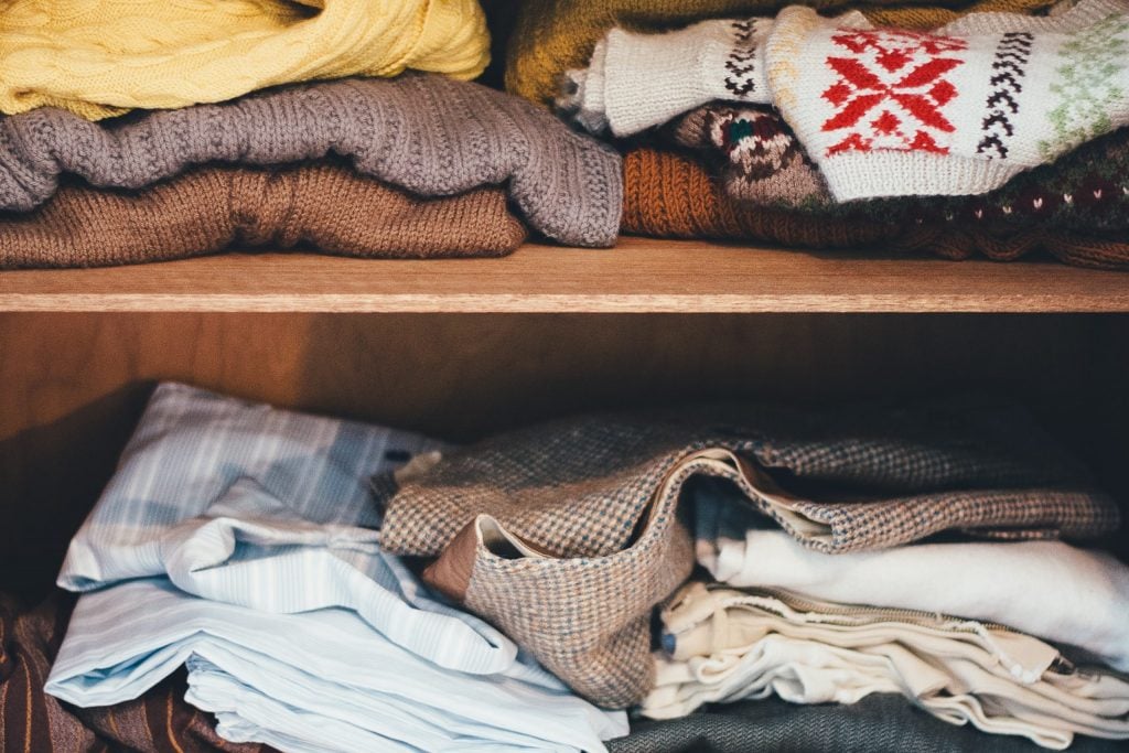 Packing your clothes by folding them is a good idea. A wardrobe full of jumpers.