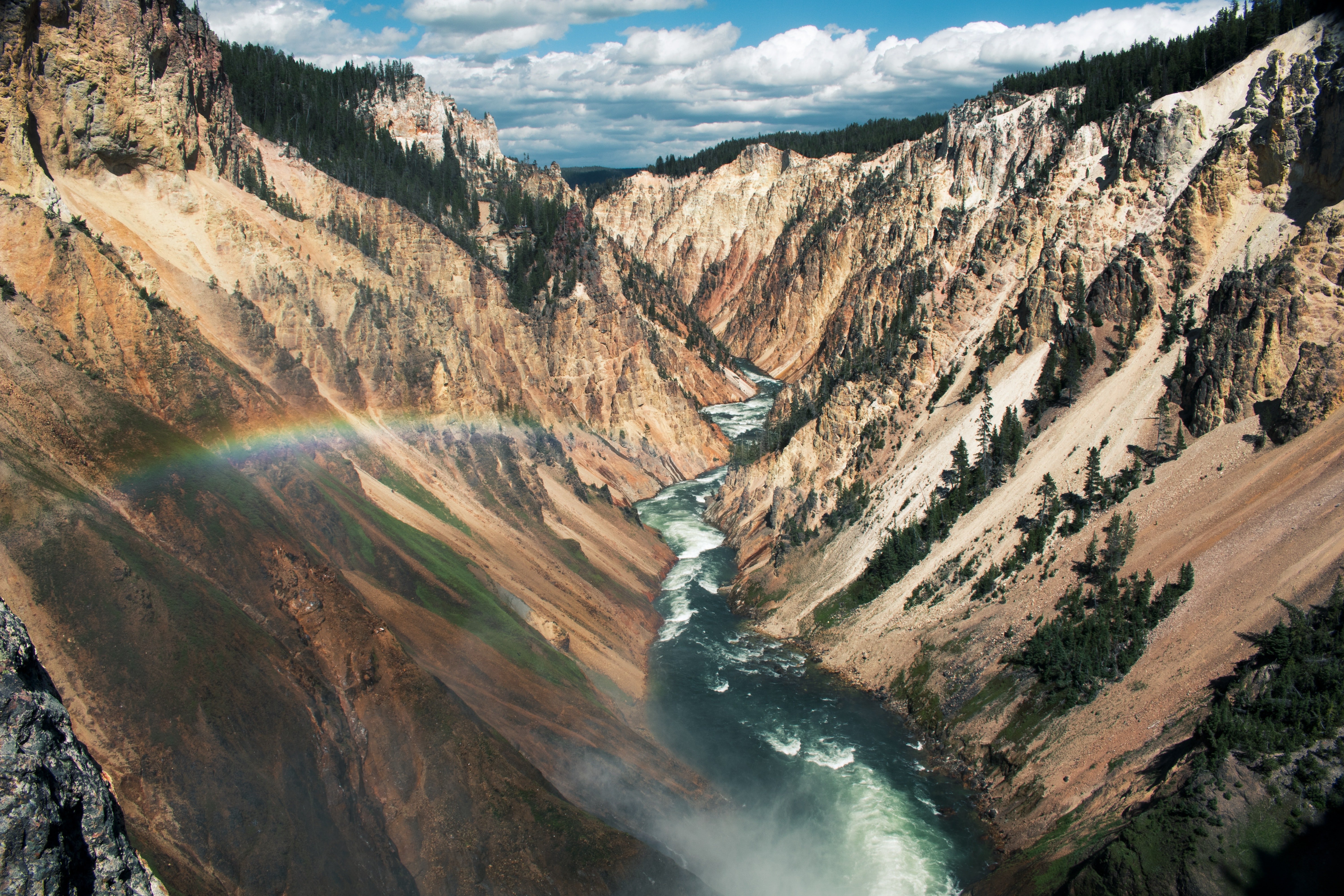 A river in a mountain gorge with a rainbow