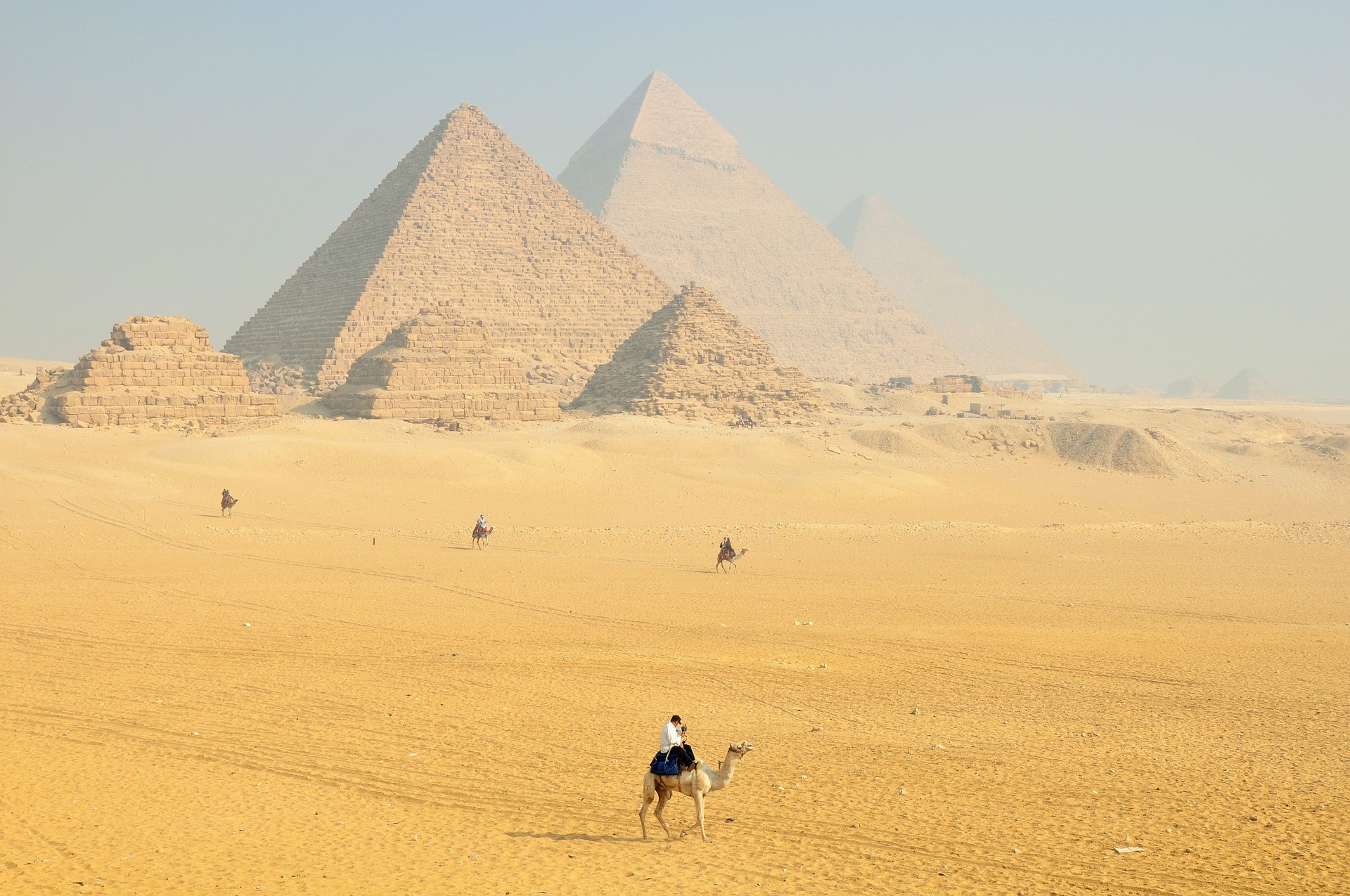 Camel riders in front of the pyramids in Egypt